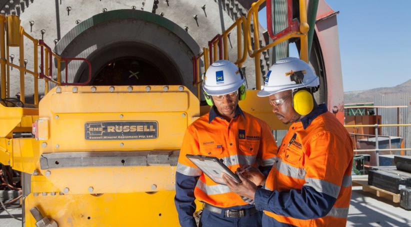 Dos Técnicos de Servicio al Cliente de RME africanos realizando el servicio a una Máquina para Revestir Molinos RUSSELL